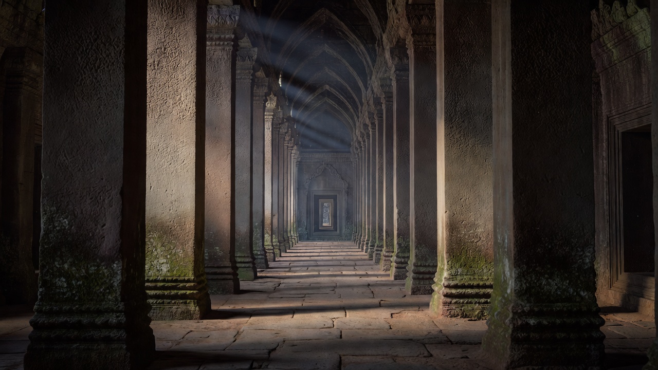 Receding row of square sandstone pillars in a shadowed gallery at Angkor Wat, Siem Reap, Cambodia